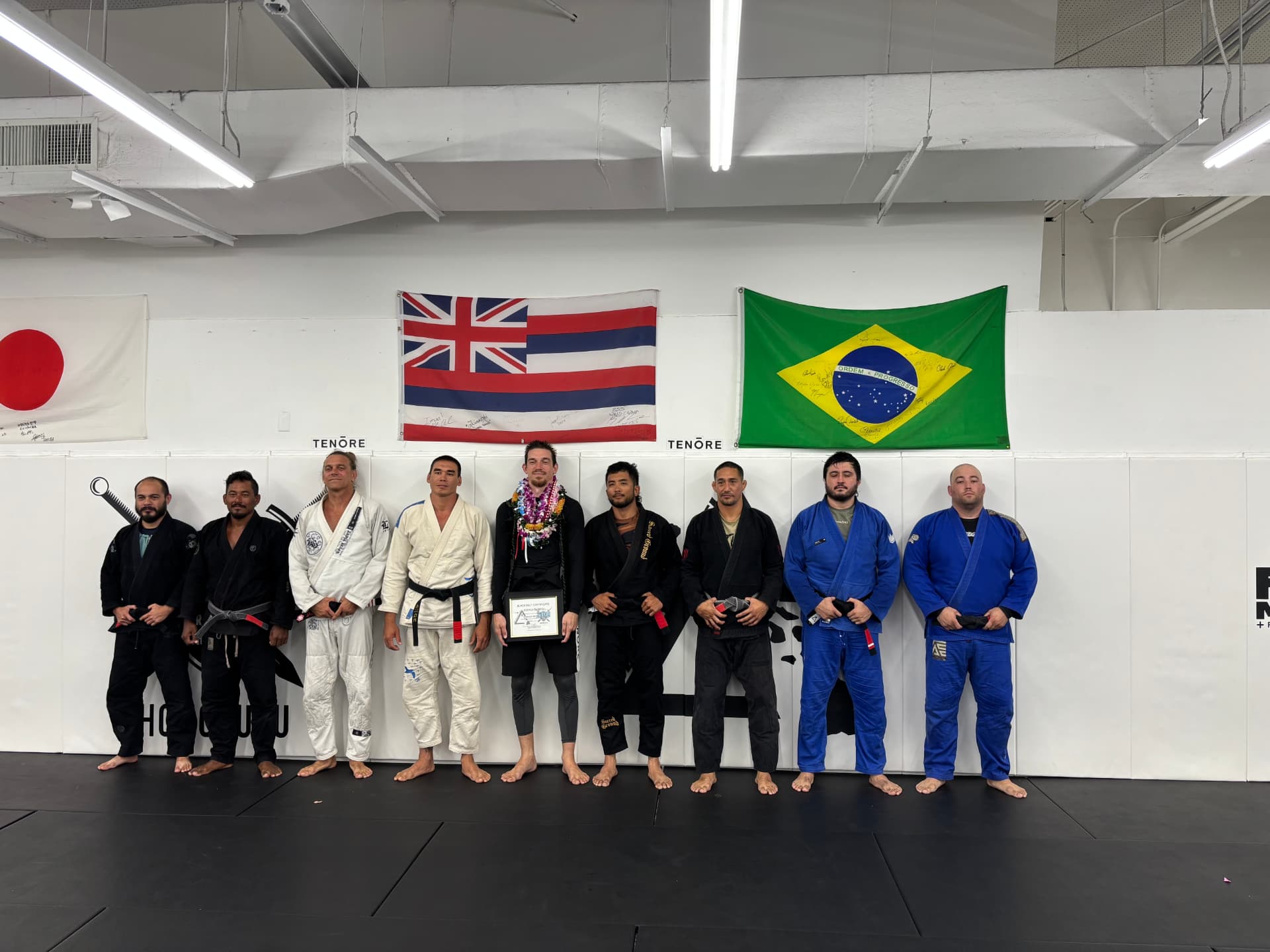 Island Jiu-Jitsu black belt promotion lineup under the Hawaii, Japan and Brazil flags
